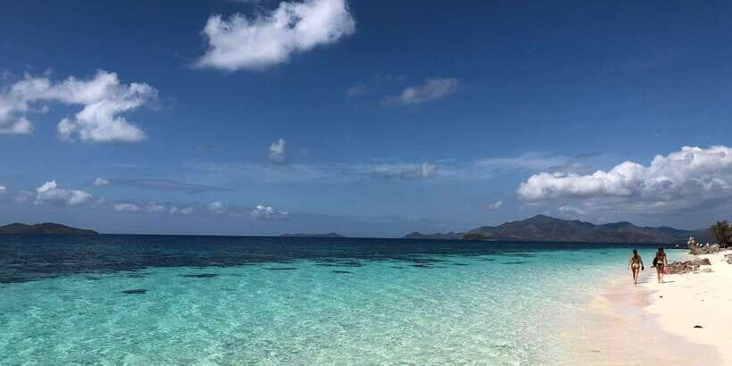 From Coron: Private Island-Hopping Cruise with Lunch - Banana Island: curved powder sand and reef just off shore