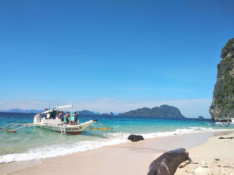 From Puerto Princesa: Day Trip to El Nido and Island Hopping - Seven Commandos Beach: white sand, coconut trees, and a pause for photos